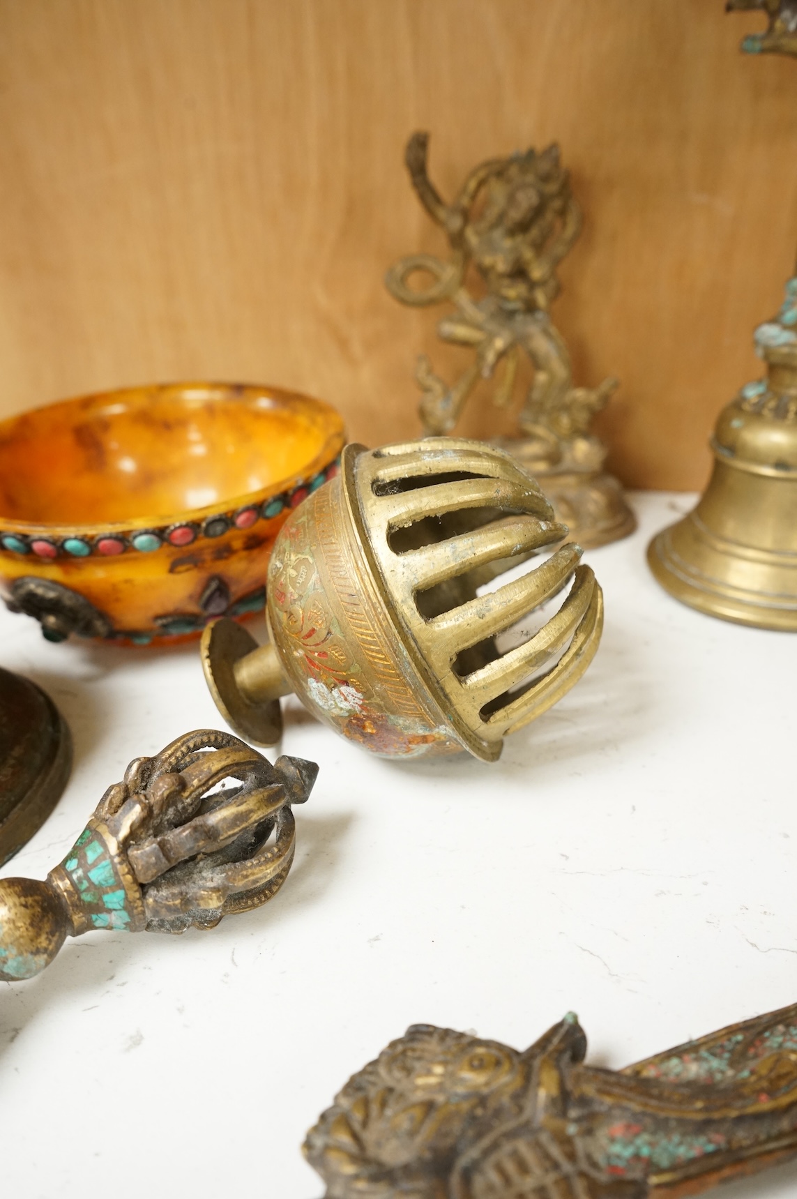 A group of Tibetan brass and mixed metal artefacts to include a brass vase with cabochon inset stones and figures of deities, largest 22cm high